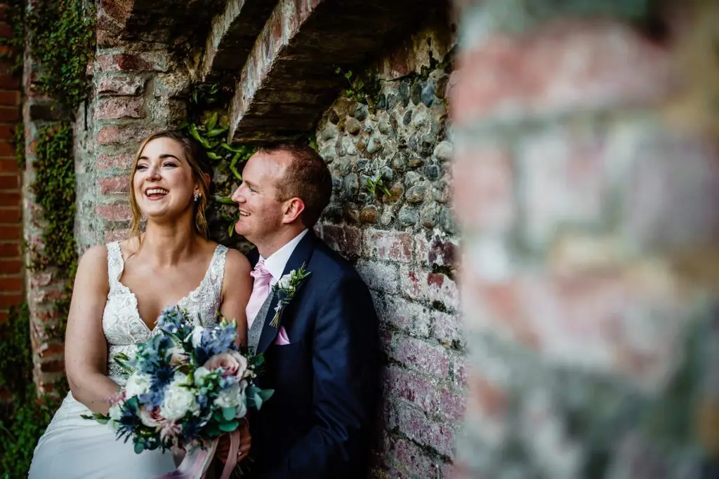 The happy bride and groom pose for a wedding photo at Oxnead Hall